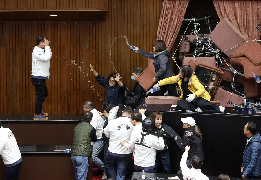 Democratic Progressive Party (DPP) lawmakers throw water to lawmakers of opposition party Kuomintang (KMT) after the DPP occupied the night to avoid the passing of the third reading of amendments to the Civil Servants Election and Recall Act and other controversial bills at the Legislative Yuan in Taipei on 20 December 2024. (I-Hwa Cheng/AFP)
