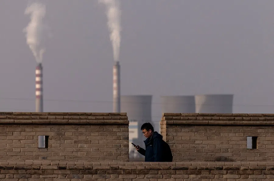 A person walks on a wall at Jiayu Pass, a strategic point along the Great Wall and the ancient Silk Road, with the chimneys of a power plant visible in the background, in Jiayuguan, Gansu province, China, on 29 October 2025. (Maxim Shemetov/Reuters)