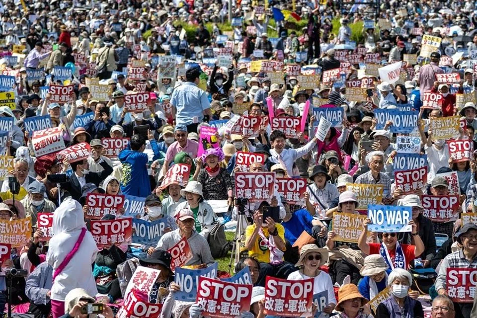 People hold placards reading “No war” and “Stop constitutional revision, military expansion” during the Grand Constitution Rally 2026 to mark Constitution Memorial Day in Tokyo on 3 May 2026. (Philip Fong/AFP)