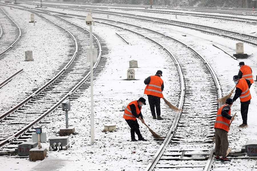 This photo taken on 15 January 2023 shows railway workers clearing snow from a railroad track during snowfall in Jiujiang, Jiangxi province, China. (AFP)