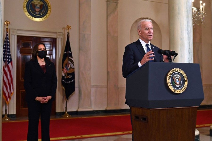 Vice President Kamala Harris (left) listens as US President Joe Biden speaks at the White House in Washington, DC on 20 April 2021.(Brendan Smialowski/AFP)