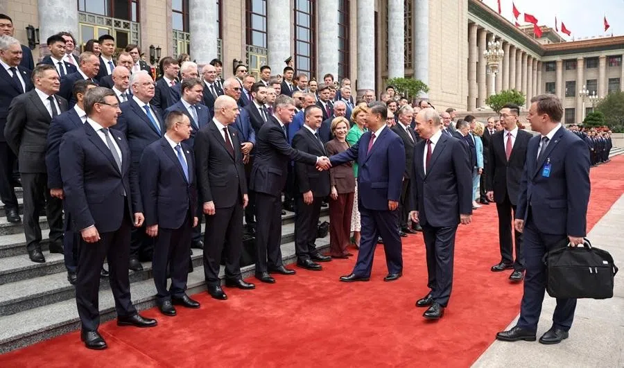 Russia's President Vladimir Putin (third from right) looks at Chinese President Xi Jinping (centre) meeting with members of the Russian delegation during a welcome ceremony at the Great Hall of the People in Beijing on 20 May 2026. (Alexander Kazakov/AFP)