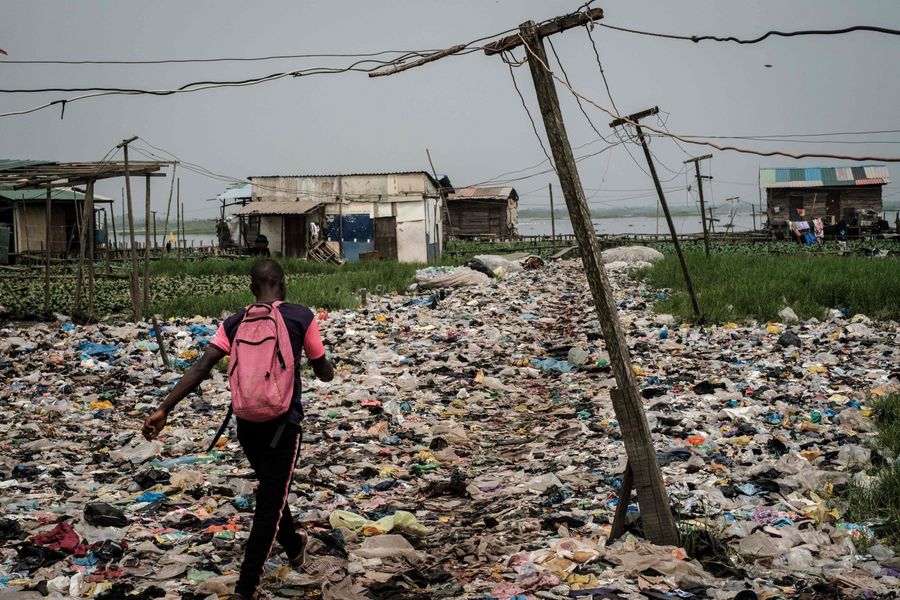 Disparity between the rich and the poor as well as social divide caused by globalisation and technological progress are insufficient in accounting for social protests. This photo shows a man walking on plastic waste used to reclaim a swamp so that the land can be developed for housing in the Mosafejo area of Lagos on February 12, 2019. (Yasuyoshi Chiba/AFP)