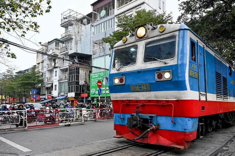 Vehicles wait as a train passes at a railway crossing in Hanoi, Vietnam, on 18 February 2025. (Nhac Nguyen/AFP)