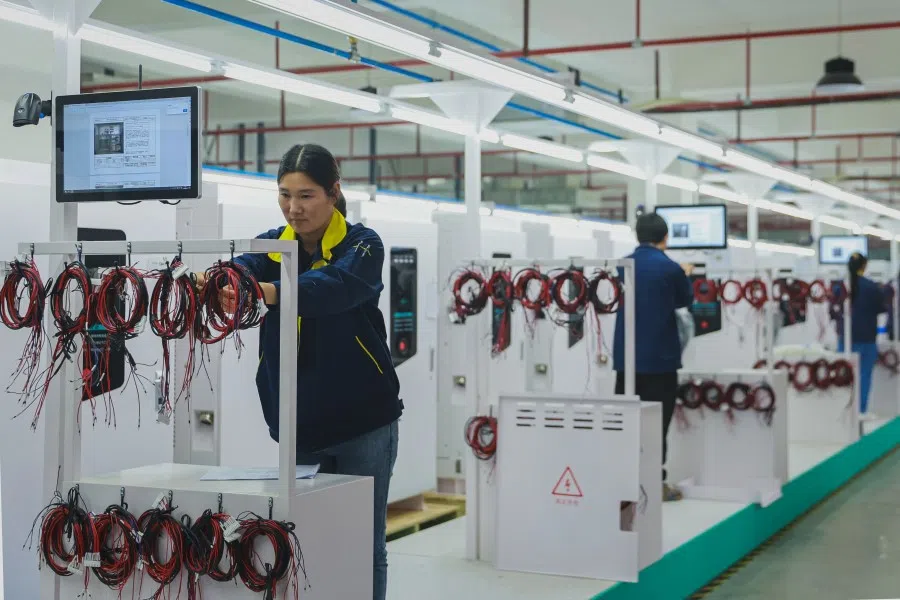 Employees work at a factory that produces charging stations for electric cars in Ruichang, in central China’s Jiangxi province on 17 April 2024. (AFP)