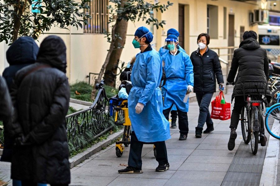 Staff wearing protective clothes transport a patient to a fever clinic at Huadong hospital in Shanghai on 19 December 2022. (Hector Retamal/AFP)