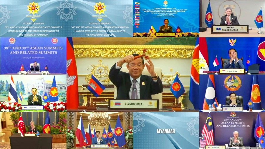 This handout photo released by the host broadcast, ASEAN Summit 2021, on 28 October 2021 shows Cambodian Prime Minister Hun Sen (centre) holding up the gavel for ASEAN chairmanship during the closing ceremony of the 2021 Association of Southeast Asian Nations (ASEAN) summit, held online on a live video conference in Brunei's capital Bandar Seri Begawan. (Handout/ASEAN Summit 2021/AFP)