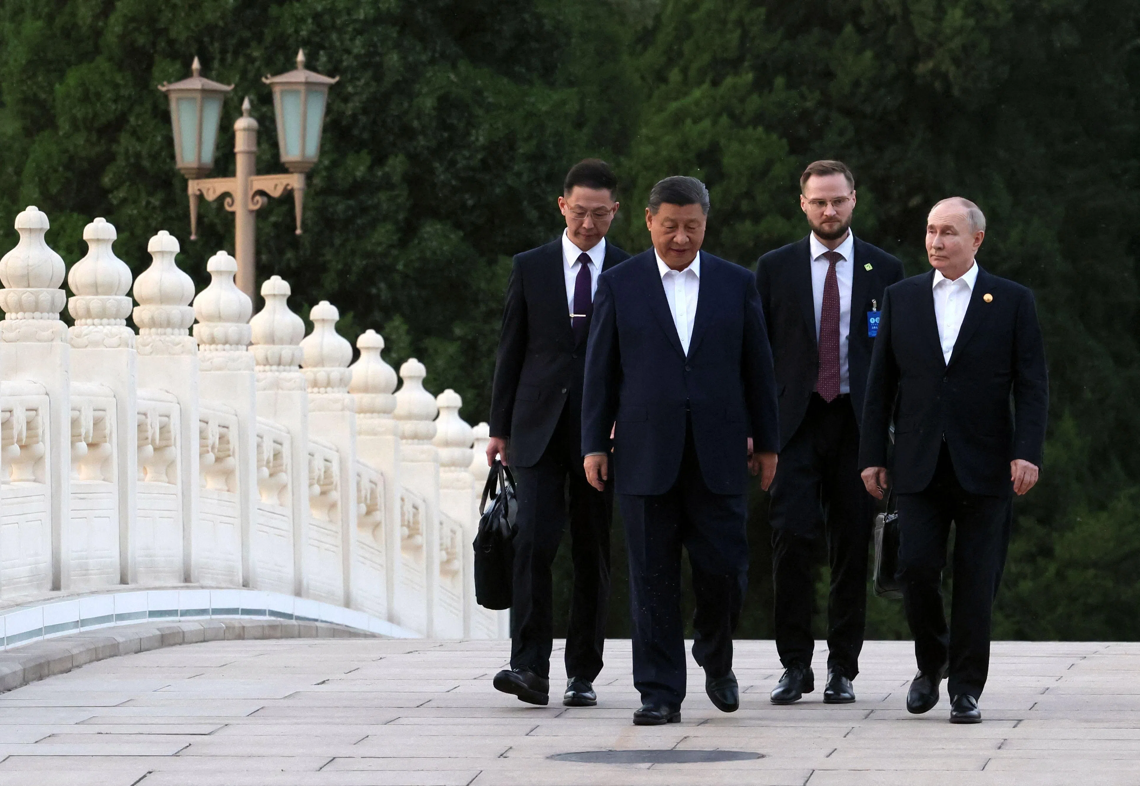 In this pool photograph distributed by the Russian state agency Sputnik, Russia’s President Vladimir Putin and China’s President Xi Jinping take a walk in Beijing on 16 May 2024. (Mikhail Metzel/AFP)