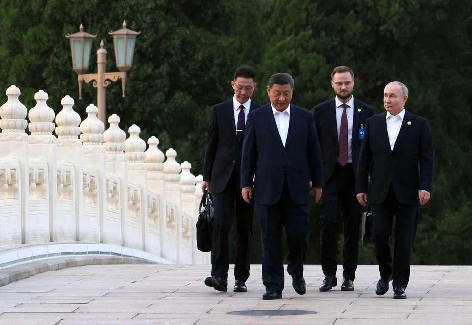 In this pool photograph distributed by the Russian state agency Sputnik, Russia’s President Vladimir Putin and China’s President Xi Jinping take a walk in Beijing on 16 May 2024. (Mikhail Metzel/AFP)