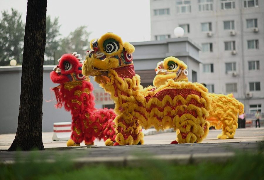 Lion dancers perform along a street in Beijing, China on 6 July 2021. (Noel Celis/AFP)