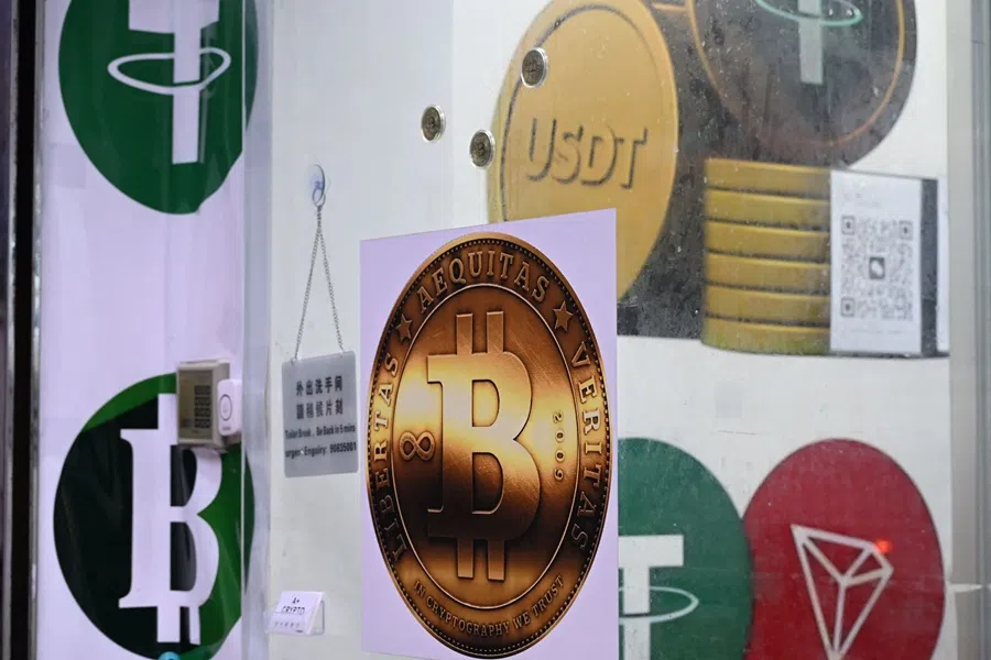 The symbols of bitcoin and the stablecoin Tether (USDT) are displayed at a cryptocurrency store in Hong Kong on 29 July 2025. (Peter Parks/AFP)