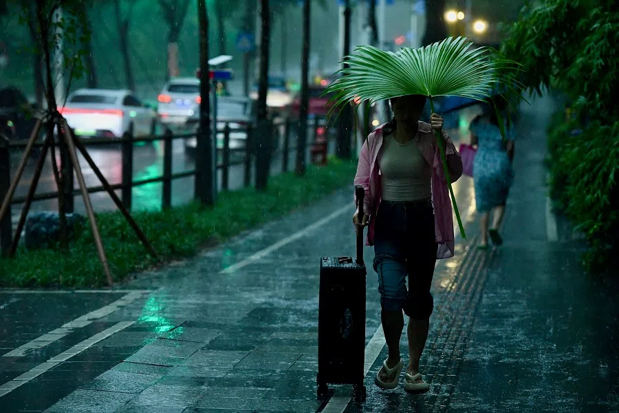 A passengers heading to the Qiaocheng East Station of Shenzhen Metro Line 1 in the rain, on 27 July 2024. (CNS)