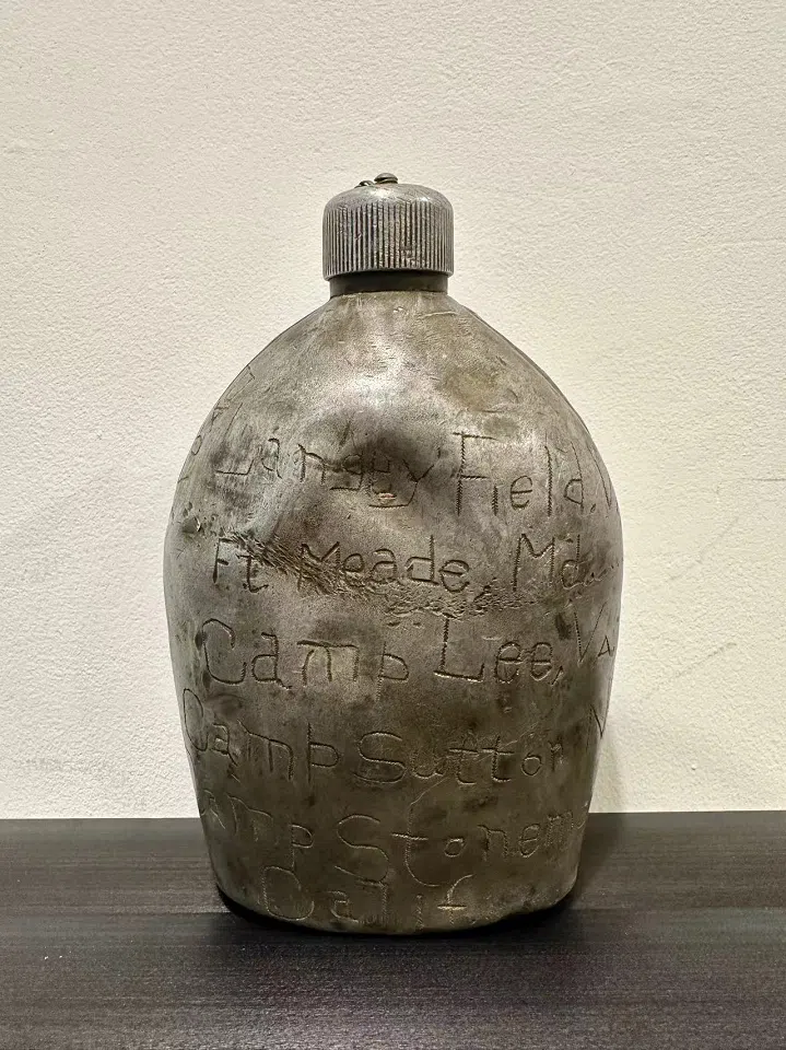 A canteen produced in 1918 during World War I that was used by an American soldier in the China-Burma-India Theatre during World War II. It is engraved with the places he travelled to, including Fort Meade (Maryland), Camp Lee (Virginia), Camp Sutton (North Carolina), Camp Stoneman (California), Deopali, Bombay and Calcutta (India), Myitkyina (Burma), Ledo Road (also known as Stilwell Road, connecting British India and China), Burma Road (connecting Myanmar with southwest China), Kunming (China), Hobart and Perth (Australia). Unfortunately, the owner of the canteen did not leave his name.