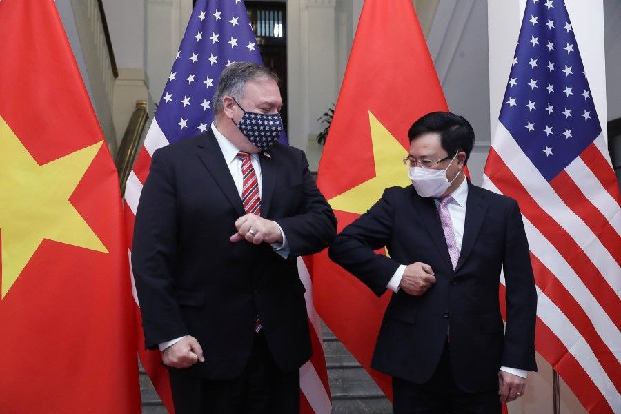 This picture taken and released on 30 October 2020 by the Vietnam News Agency shows Vietnam's Foreign Minister Pham Binh Minh (R) bumping elbows to greet US Secretary of State Mike Pompeo before a meeting in Hanoi. (Bui Lam Khanh/Vietnam News Agency/AFP)