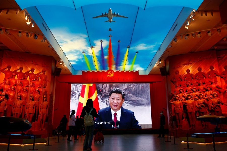 Visitors stand in front of a giant screen displaying Chinese President Xi Jinping next to a flag of the Communist Party of China, at the Military Museum of the Chinese People's Revolution in Beijing, China, 8 October 2022. (Florence Lo/File Photo/Reuters)