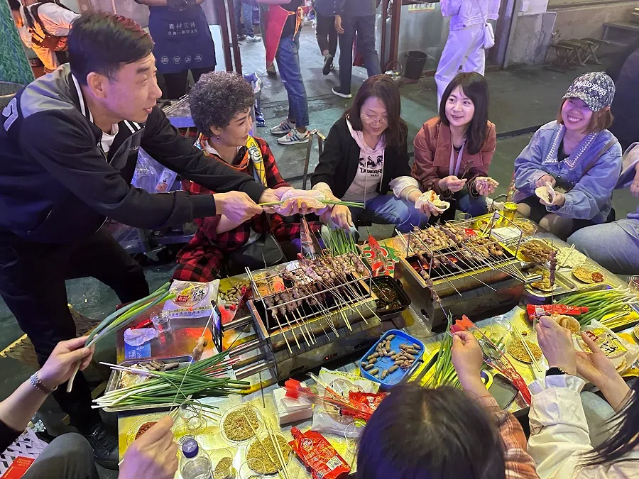 People eat barbecue skewers in Zibo, Shandong. (Photo: Daryl Lim)