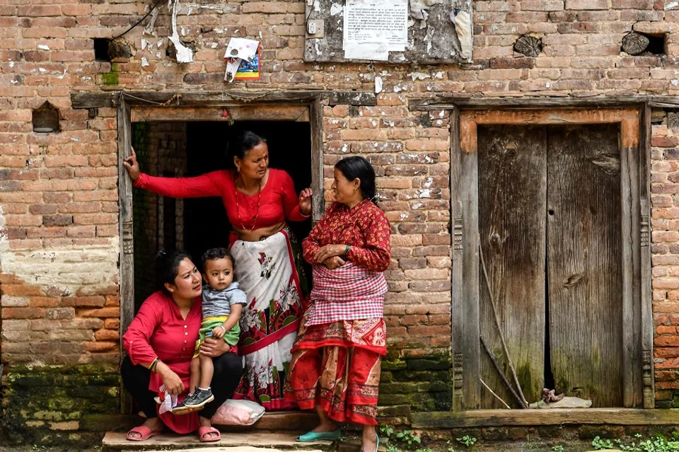 Residents wait to watch the processions of the 'Ropain' or rice plantation festival and the 'Gai Jatra' Hindu festival at Khokana village on the outskirts of Kathmandu on 5 August 2020. (Prakash Mathema/AFP)