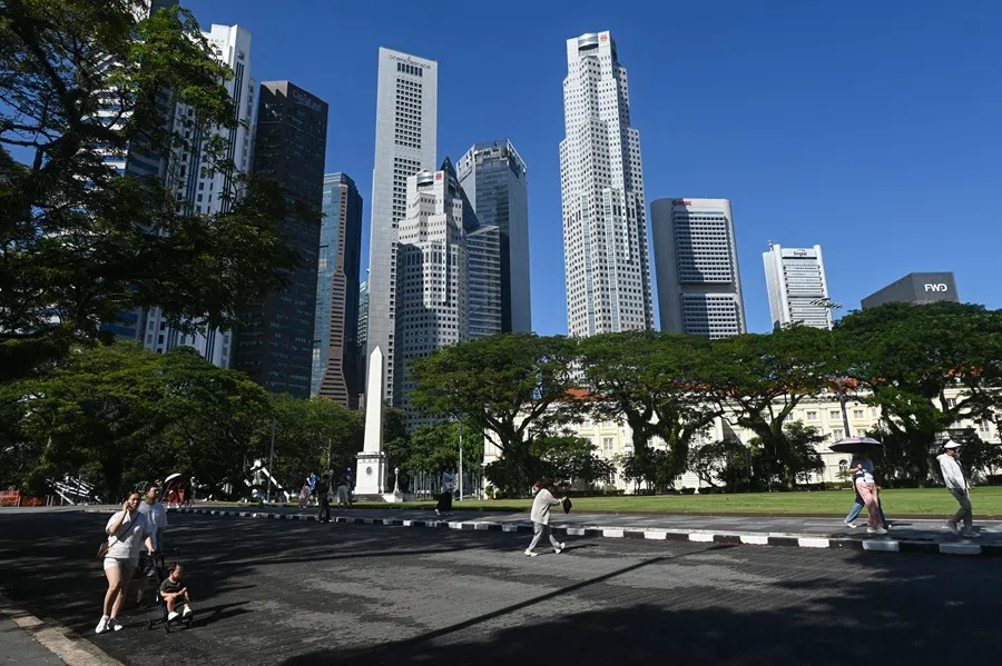 Pedestrians walk past high-rise office buildings in Singapore’s financial district on 6 May 2025. (Roslan Rahman/AFP)