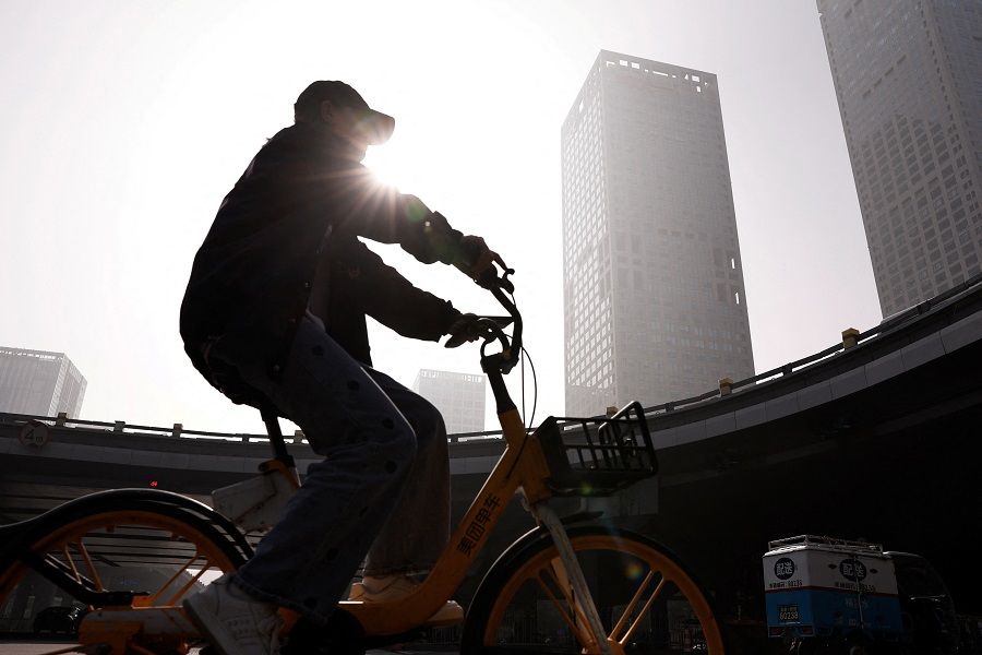 A person rides a bike past Beijing's central business district in China, on 1 November 2023. (Tingshu Wang/Reuters)
