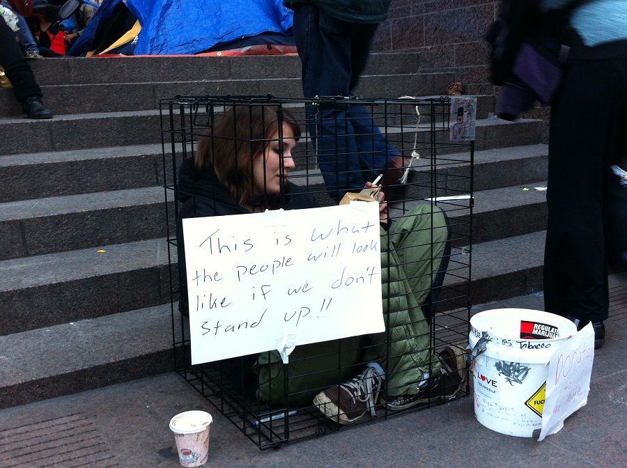 An activist makes her point by sitting in a cage at the Occupy Wall Street Movement in New York, US. (SPH Media)
