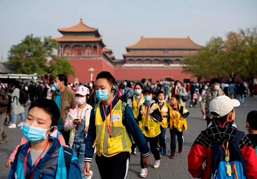 People wearing face masks walk outside the Forbidden City during the country's national "Golden Week" holiday in Beijing, China, on 8 October 2020. (Noel Celis/AFP)