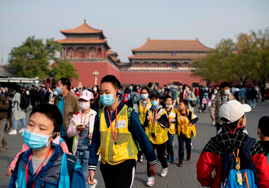 People wearing face masks walk outside the Forbidden City during the country's national "Golden Week" holiday in Beijing, China, on 8 October 2020. (Noel Celis/AFP)