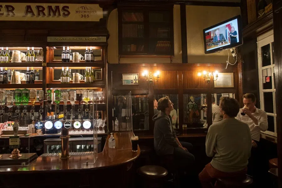 Patrons watch Britain's Prime Minister Boris Johnson addressing the nation in London on 22 September 2020. (Justin Tallis/AFP)