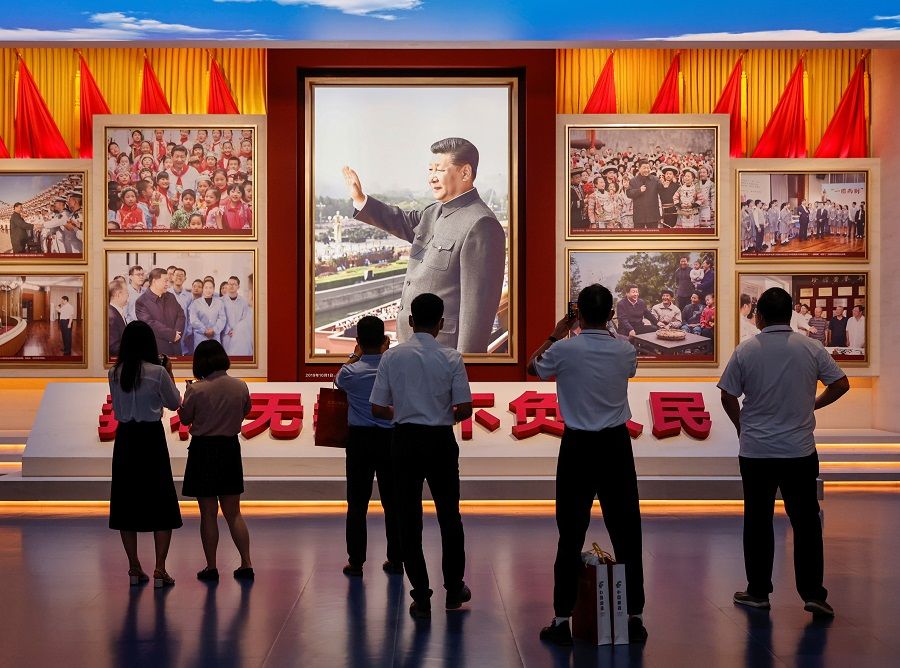 People look at images showing Chinese President Xi Jinping at the Museum of the Communist Party of China that was opened ahead of the 100th founding anniversary of the Party in Beijing, China, 25 June 2021. (Thomas Peter/Reuters)