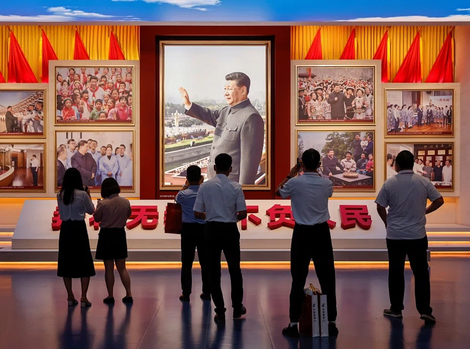 People look at images showing Chinese President Xi Jinping at the Museum of the Communist Party of China that was opened ahead of the 100th founding anniversary of the Party in Beijing, China, 25 June 2021. (Thomas Peter/Reuters)