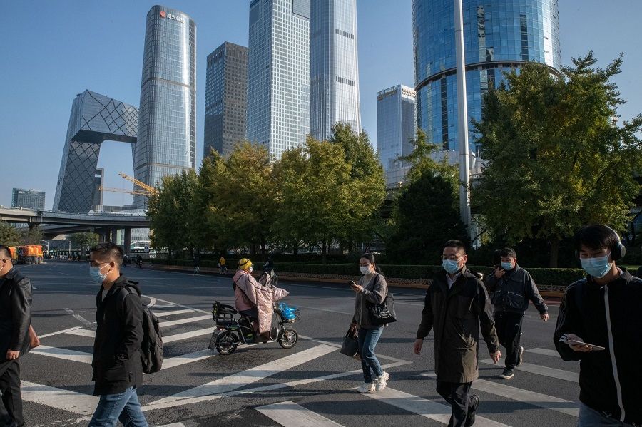 Pedestrians cross a road in Beijing, China, on 24 October 2022. (Bloomberg)