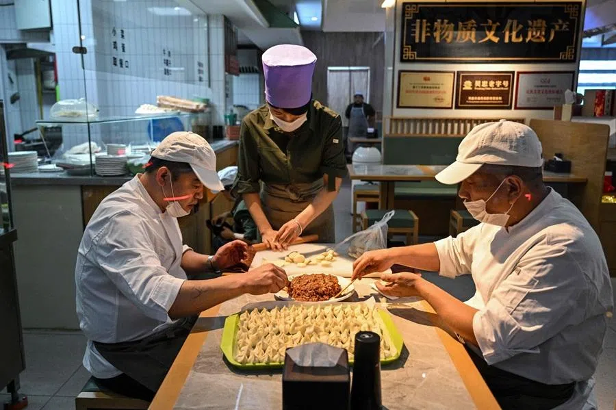 Culinary workers make dumplings in a restaurant in Jing'an district in Shanghai on 31 March 2026. (Hector Retamal/AFP)