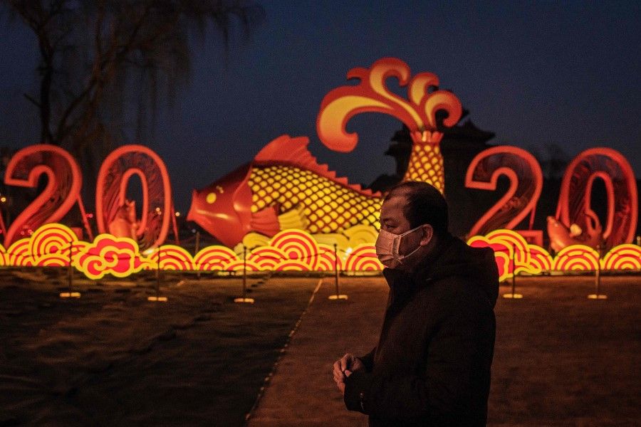 A man walks past a Chinese New Year decoration outside the Forbidden City in Beijing, 25 January 2020, the first day of the first lunar month. (Nicolas Asfouri/AFP)