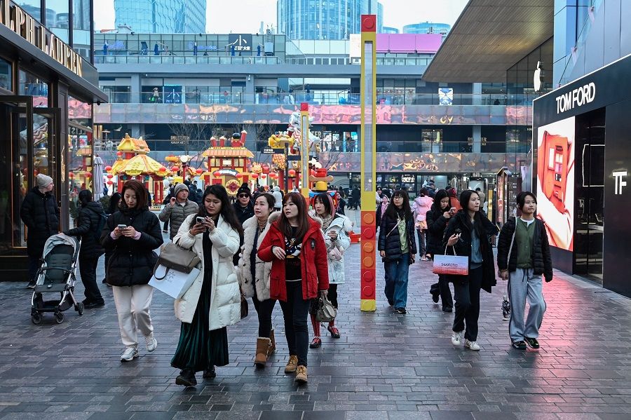 People visit a shopping mall in Beijing, China, on 18 February 2024. (Pedro Pardo/AFP)