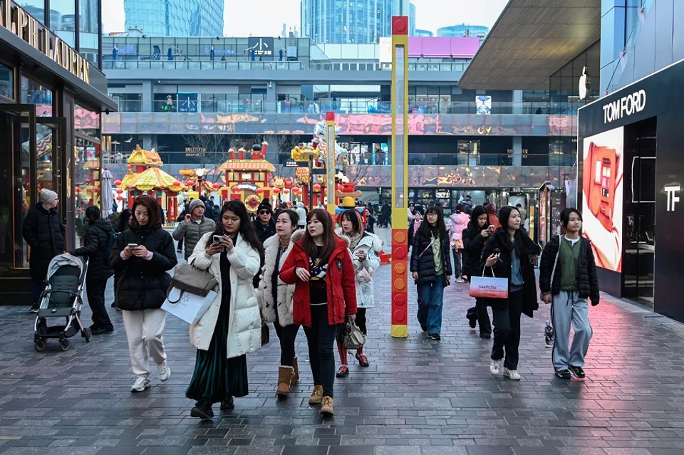 People visit a shopping mall in Beijing on 18 February 2024. (Pedro Pardo/AFP)