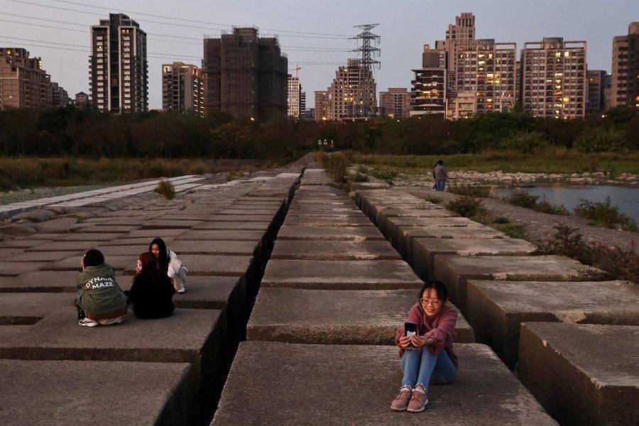 People take photos on the exposed riverbed of Taiwan's Touqian river, a main water source for Hsinchu Science Park where major semiconductor companies are based, in Hsinchu, Taiwan during an island-wide drought on 12 March 2021. (Ann Wang/File Photo/Reuters)