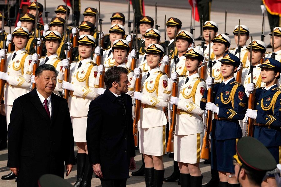 Chinese President Xi Jinping (left) and his French counterpart Emmanuel Macron review an honour guard during the official welcoming ceremony in Beijing, China, on 6 April 2023. (Ng Han Guan/Pool/AFP)
