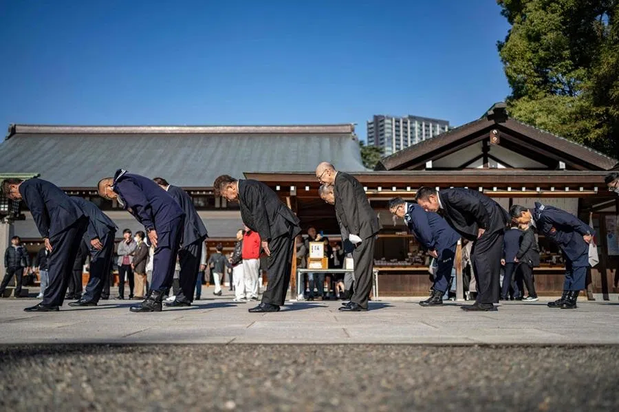 This picture taken on 8 December 2025 shows members of the ultra-nationalist group Taikosha bowing during a prayer ritual at Yasukuni shrine on the 84th anniversary of Japan's Pearl Harbour attack, before departing for a rally in Tokyo. (Yuichi Yamazaki/AFP)
