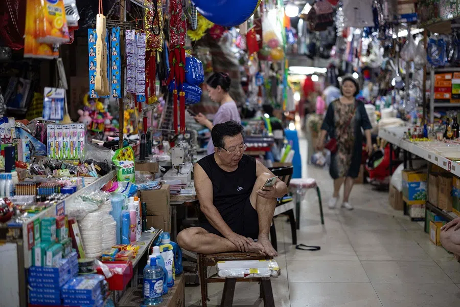 A vendor waits for customers at a market in Shenyang, in northeastern China’s Liaoning province on 9 August 2024. (AFP)