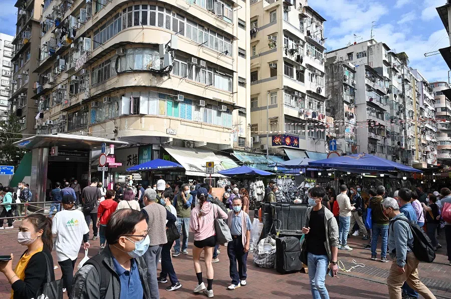 Shoppers walk through a market street in Kowloon district of Hong Kong, China, on 4 December 2022. (Peter Parks/AFP)