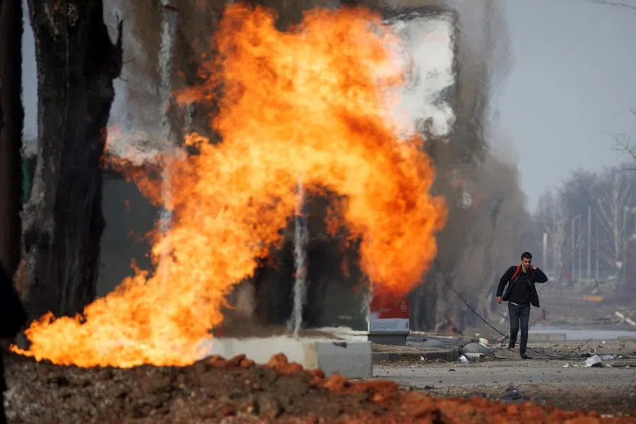 A man walks past a burning gas pipeline that was hit during shelling in northern Kharkiv, Ukraine, as Russia's attack on Ukraine continues, 31 March 2022. (Thomas Peter/Reuters)