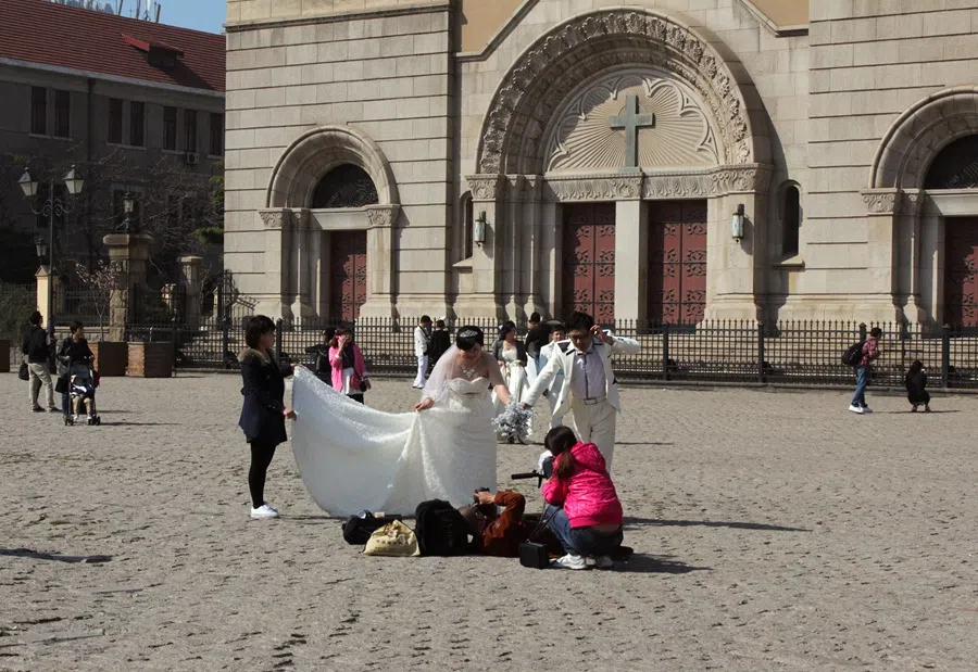 Wedding couple at the foot of St Michael’s Cathedral (1934) in the Shinan district.