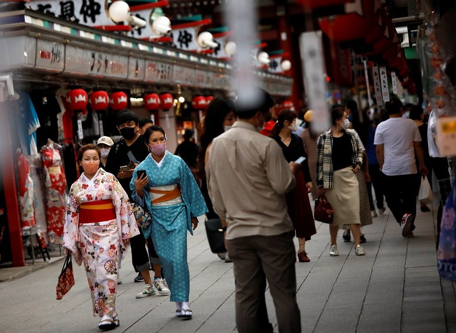 Kimono-clad tourists wearing protective face masks walk along Nakamise Street at Asakusa district, a popular sightseeing spot, amid the Covid-19 outbreak in Tokyo, Japan, 13 October 2020. (Issei Kato/Reuters)