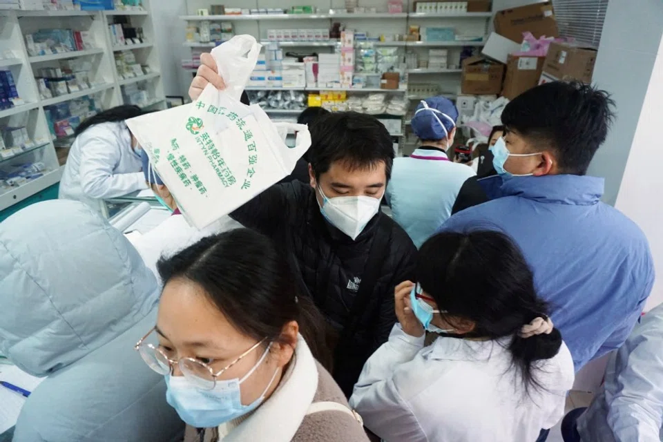 People line up to buy antigen test kits for Covid-19, at a pharmacy in Hangzhou, Zhejiang province, China, 19 December 2022. (China Daily via Reuters)