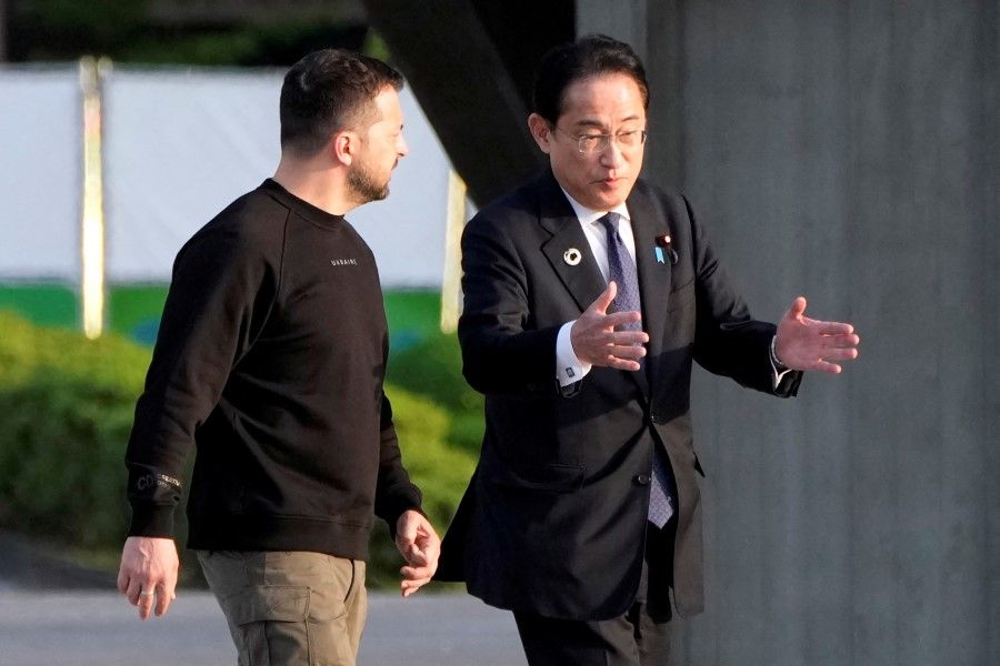 Ukrainian President Volodymyr Zelenskyy (left) is escorted by Japanese Prime Minister Fumio Kishida (right) to the Cenotaph for the Victims of the Atomic Bomb at the Hiroshima Peace Memorial Park, after Zelenskiy was invited to the Group of Seven nations' summit in Hiroshima, Japan, 21 May 2023. (Eugene Hoshiko//Reuters)