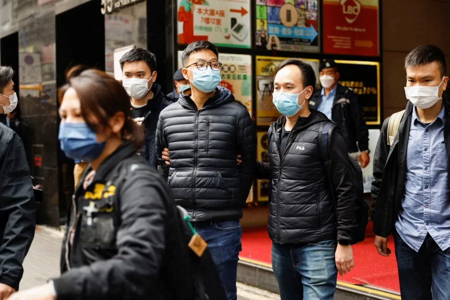Stand News acting chief editor Patrick Lam, one of the six people arrested "for conspiracy to publish seditious publication" according to Hong Kong Police Force's National Security Department, is escorted by police as they leave after the police searched his office in Hong Kong, China, 29 December 2021. (Tyrone Siu/Reuters)