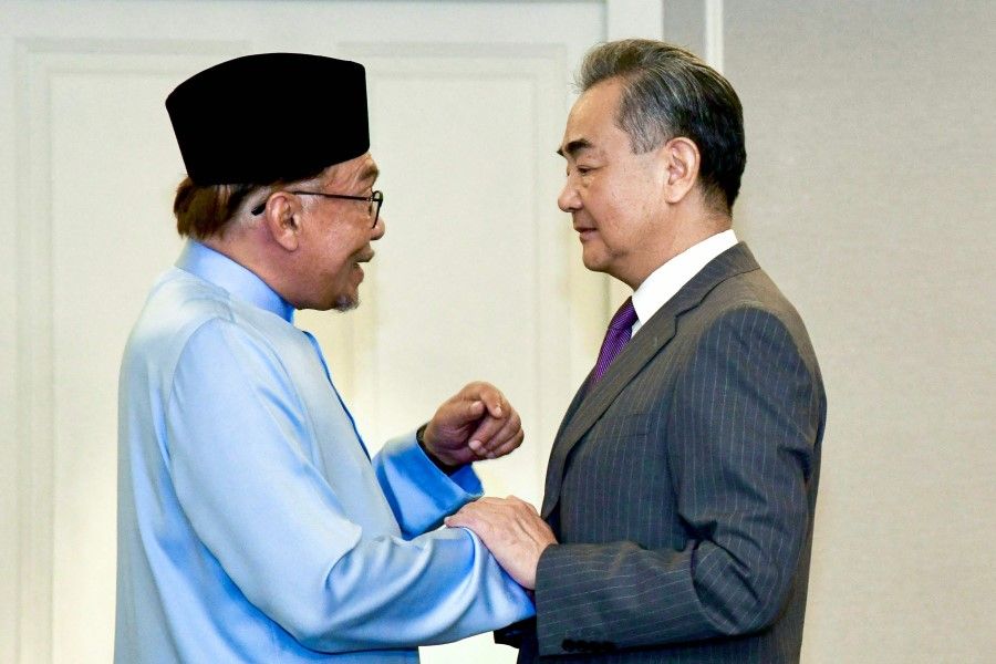 This handout picture taken and released by Prime Minister's Department of Malaysia on 11 August 2023 shows Malaysia Prime Minister Anwar Ibrahim (left) shaking hands with Chinese Foreign Minister Wang Yi (right) during their meeting at the Eastern & Oriental Hotel in Georgetown on Penang island. (Muhammad Faiz Norzani/Prime Minister's Department of Malaysia/AFP)