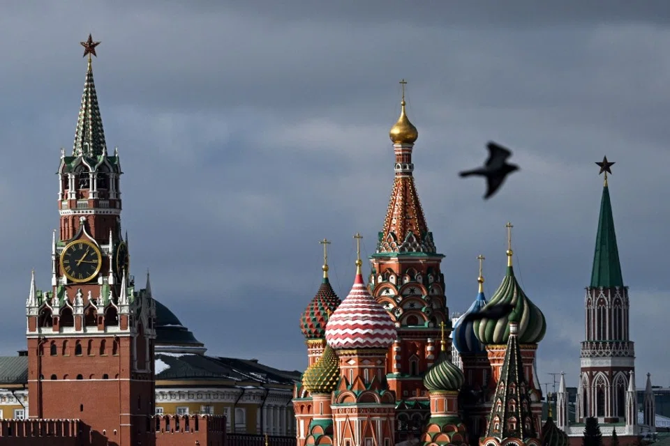 A pigeon flies in front of the Kremlin's Spasskaya tower (left) and Saint Basil's cathedral (centre) in Moscow on 1 March 2023. (Kirill Kudryavtsev/AFP)