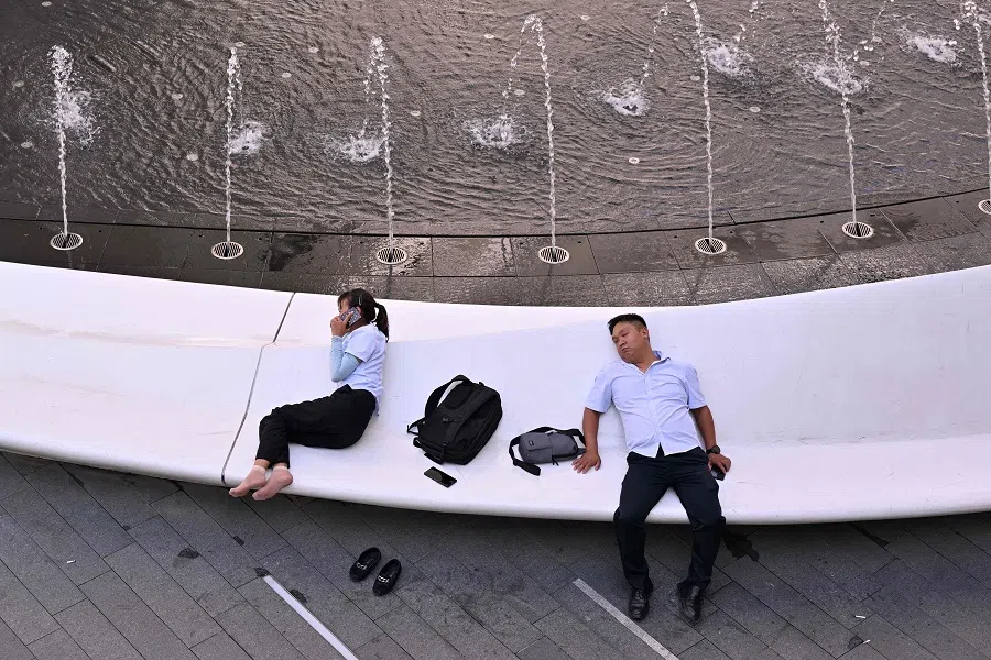 People rest near a fountain at a shopping mall in Beijing, China on 18 July 2024. (Adek Berry/AFP)