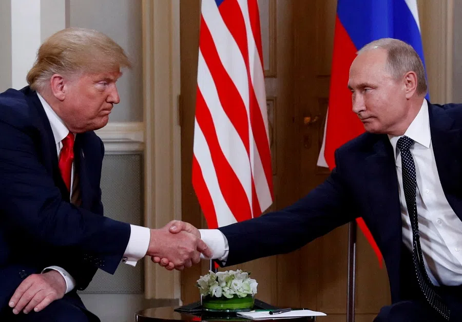 US President Donald Trump and Russia’s President Vladimir Putin shake hands as they meet in Helsinki, Finland, on 16 July 2018.  (Kevin Lamarque/Reuters)