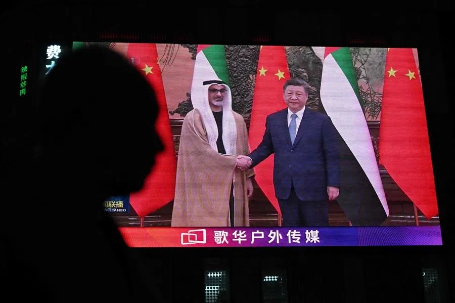 News footage on a giant screen outside a shopping mall shows China's President Xi Jinping meeting with Abu Dhabi's Crown Prince Sheikh Khaled bin Mohamed bin Zayed Al Nahyan in Beijing on 14 April 2026. (Pedro Pardo/AFP)
